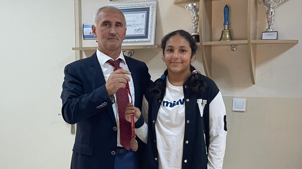 “U11 Serbest Bayanlar Güreş Turnuvası” nda Türkiye 3. sü olan 6. Sınıf öğrencimiz Ezgi Ertan ‘a madalyasını Okul Müdürümüz Niyazi Aydın takdim etti. 